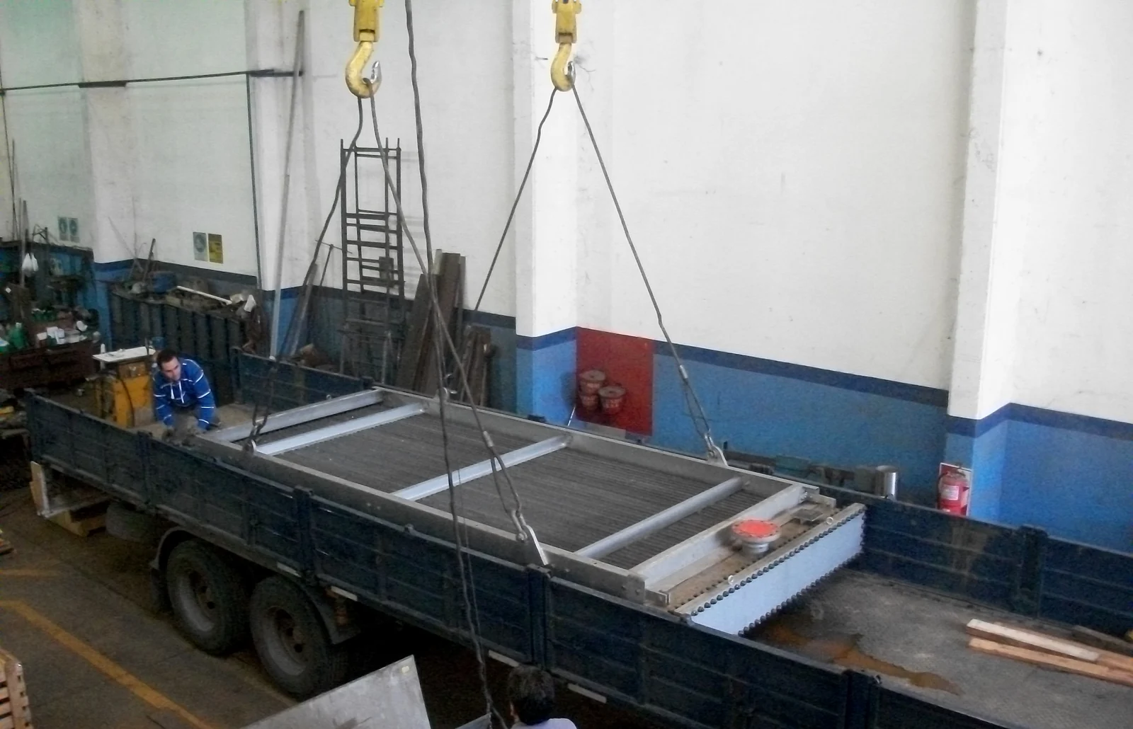 Haz de aero enfriador izado con puente grúa durante su carga sobre camión