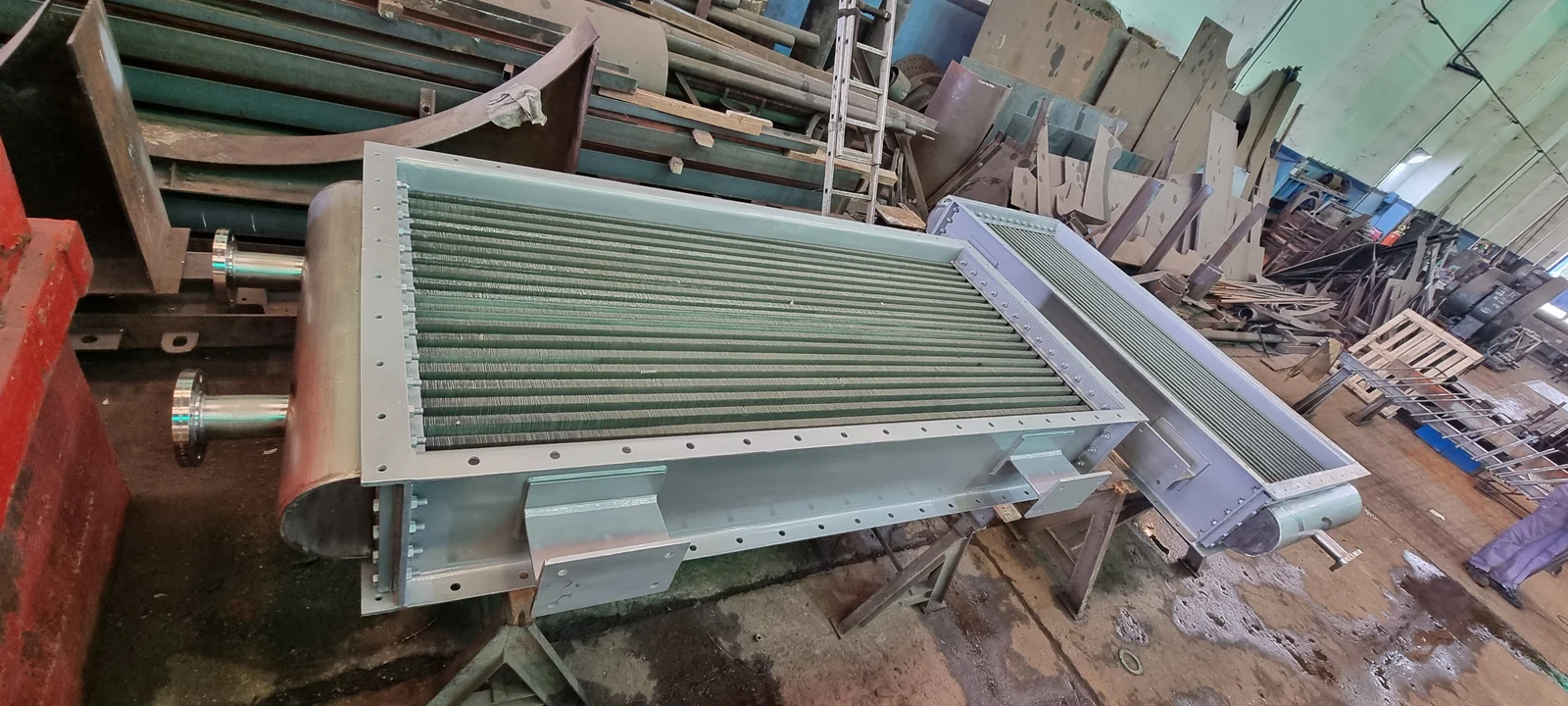 Haces de tubos aletados de distinto porte en el taller, con marcos y cabezales terminados