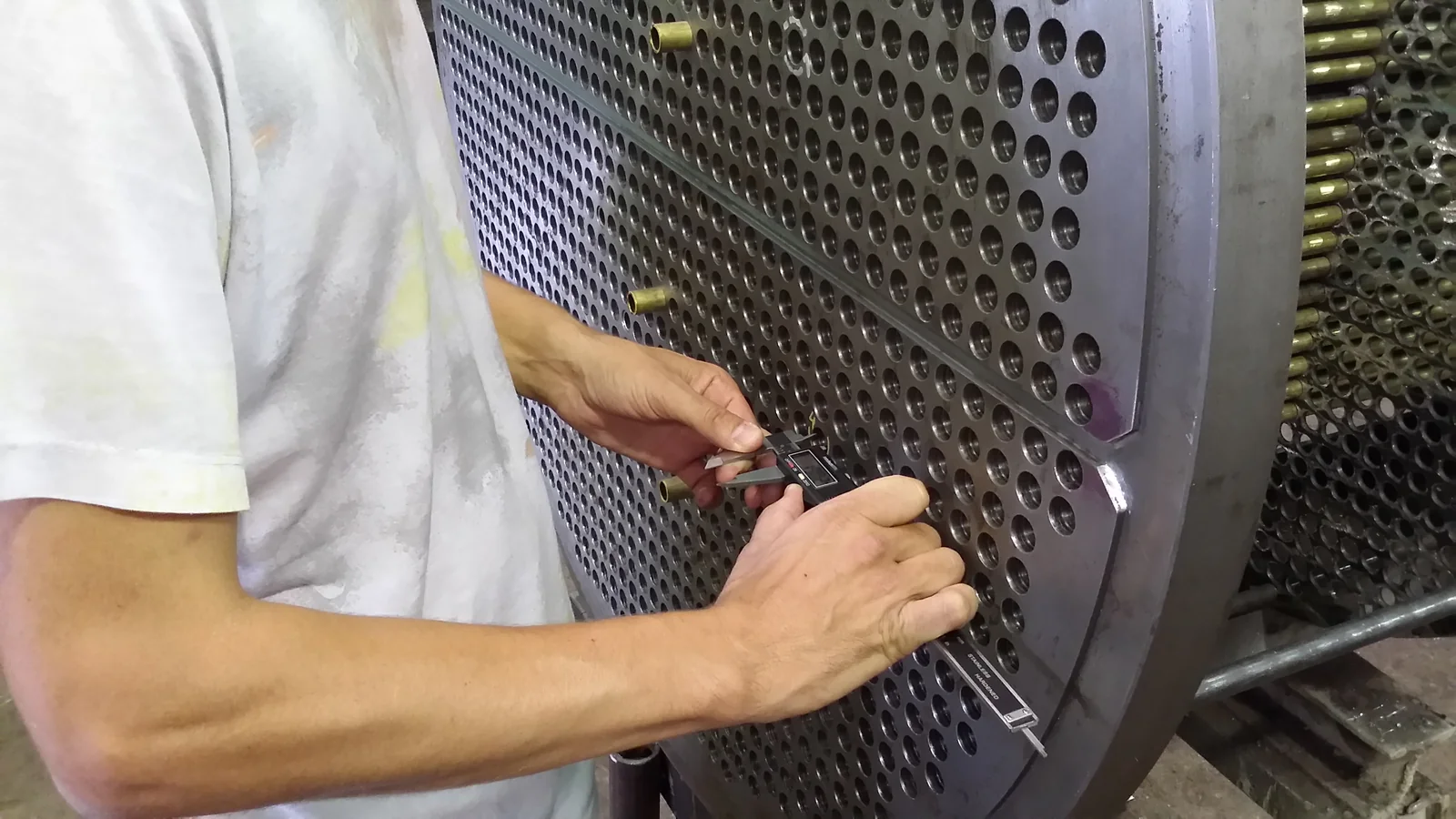 Calibre verificando dimensiones sobre un espejo con tubos montados