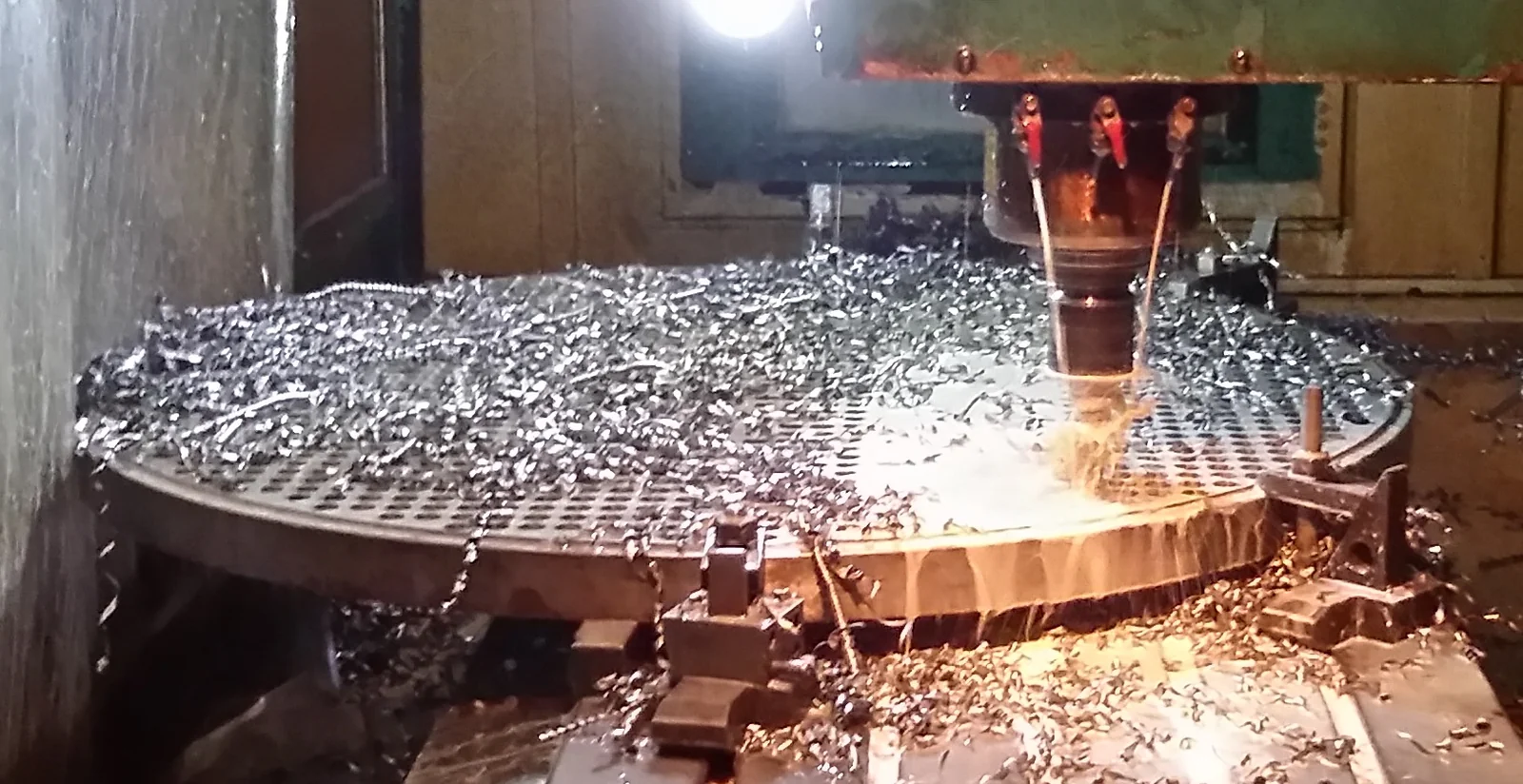 Espejo de gran diámetro perforándose en CNC con abundante viruta