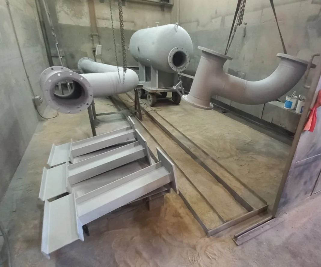 Desaireador, cañerías y escalera pintados dentro de la cámara