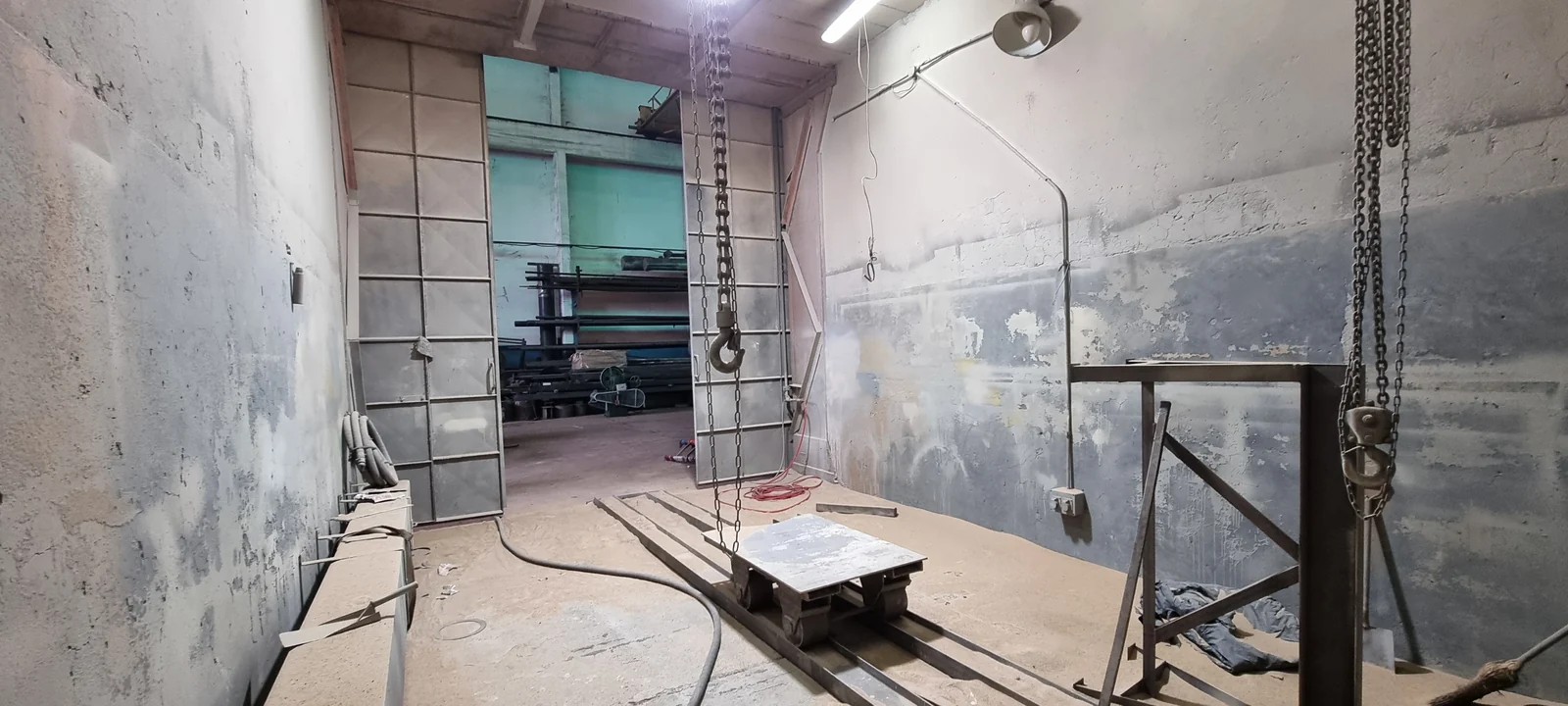Cámara de arenado y pintura vista desde el acceso, con las puertas abiertas